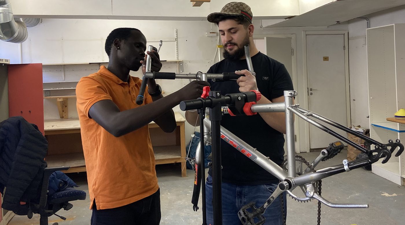 Bild på ungdomar som lagar en cykel.